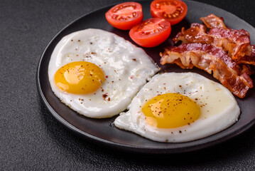 English breakfast with fried eggs, bacon, beans, tomatoes, spices and herbs