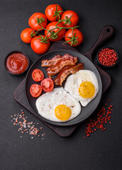English breakfast with fried eggs, bacon, beans, tomatoes, spices and herbs
