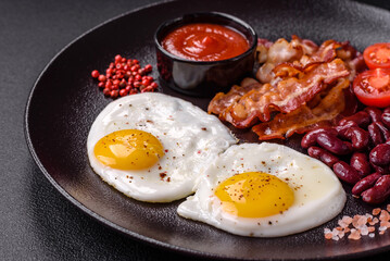English breakfast with fried eggs, bacon, beans, tomatoes, spices and herbs