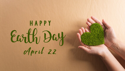 Hands holding green heart on brown background. World environment day, earth day and save earth concept.