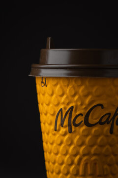 KYIV, UKRAINE - January 06: Close up shot of yellow McDonald's paper cup of coffee in a popular fast food restaurant. McCafe coffee cup from McDonalds on the black background
