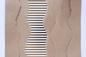 wavy striped paper and brown cardboard paper with torn wavy edges arranged in staggered, layered...