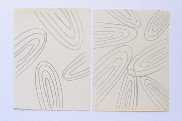 two blank sheets with repeating curving graphite lines