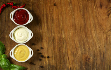 various types of sauce ketchup mayonnaise mustard on wooden background