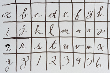 alphabet and numbers in black ink on paper with wavy line grid 