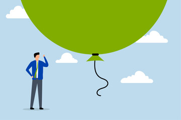 Stock market, scared businessman investor standing under a huge big balloon bubble.