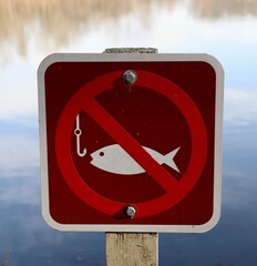 A close view of the brown and red no fishing sign.