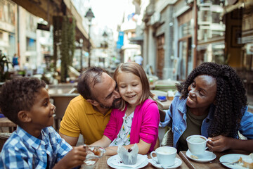 Obraz na płótnie Canvas Happy multiethnic family enjoying time at a cafe together
