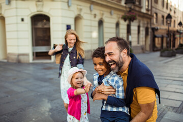 Joyful diverse family having fun on a city walk