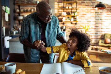 Father helping son with homework in kitchen - obrazy, fototapety, plakaty