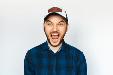 Studio portrait of young man screaming on background of white.