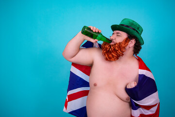 A funny fat man in a leprechaun costume drinks green beer on St. Patrick's Day.