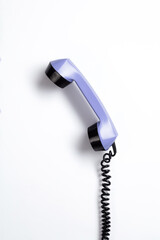 Hanging telephone receiver. Phone from the 1970's. Old-fashioned phone from the seventies on a white background. - obrazy, fototapety, plakaty