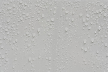 Water drops on white background texture. backdrop glass covered with drops of water. grey bubbles. condensate