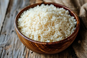 Fototapeta na wymiar Wooden Bowl Filled With Rice on Wooden Table