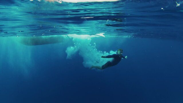 Surfer jumps from the boat into the clean water in the Maldives