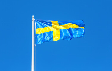 Flag of Sweden flying in the wind against a blue sky - 771627675
