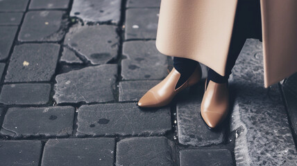 fashionable beige shoes in operation. women's legs in beige shoes close-up on a city street. quiet luxury in clothes. - obrazy, fototapety, plakaty