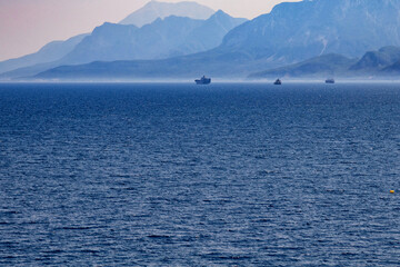 View of mountains and ships in a blue haze off the Mediterranean coast. Antalya, Turkey.