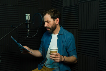 Male voice actor preparing for a recording session in a soundproof studio