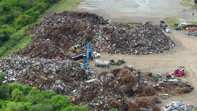 Steel mill junkyard with cranes recycling old scrap metal. Equipment at industrial scrapyard.