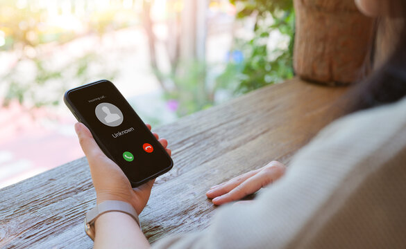 Woman holding mobile phone with incoming call from an unknown caller. scammer or stranger, Hoax person with fake identity, Prank caller, anonymous, Fraud or phishing concept, beware of unwanted calls,