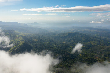 A mountain range with a forest through the clouds. Slopes of mountains with evergreen vegetation. Sri Lanka, Lipton's Seat.