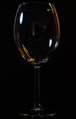 a glass of wine on a black background, the silhouette of a transparent glass