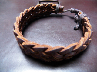 One tressed bracelet accesory on and in brown leather material close-up in a high angle view
