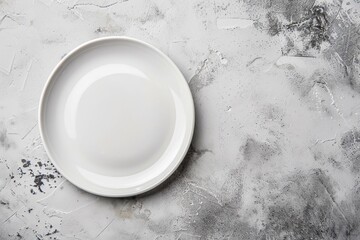 Top view of an empty white porcelain plate resting on a white stone table, ready to be filled with food
