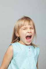 Screaming young girl against grey background