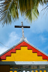 Brightly colored gable topped with a cross