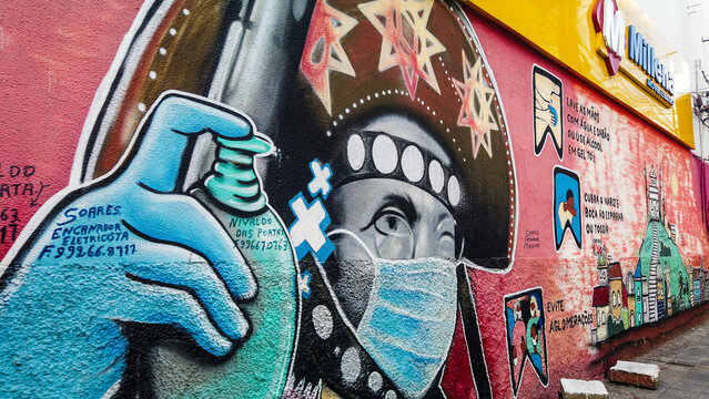 Detail of graffiti from the city of Caruaru depicting the cangaceiro Lampi&atilde;o wearing a mask and holding hand sanitizer gel.