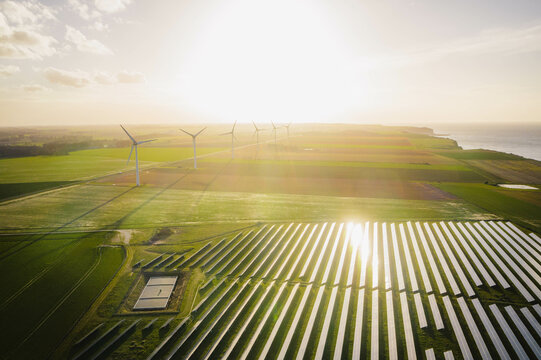 Wind turbines and solar panels farm in a field. Renewable green energy. Sunny landscape, electric energy generator for clean energy producing concept