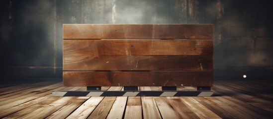 A brown wooden box rests on the hardwood flooring of a dark room, showcasing the beauty of wood as a building material with its rich grain pattern and symmetry