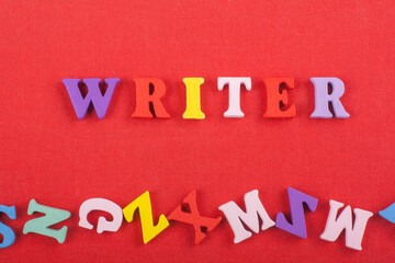 WRITER word on red background composed from colorful abc alphabet block wooden letters, copy space...