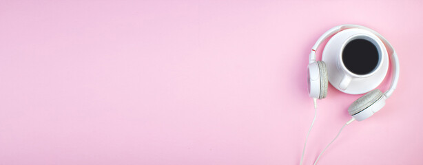 Headphones, mobile phone, idiobook, coffee cup on a pink background. The concept of leisure and...