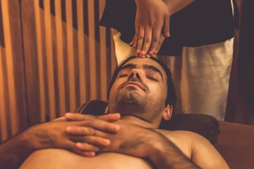 Rolgordijnen Caucasian man enjoying relaxing anti-stress head massage and pampering facial beauty skin recreation leisure in warm candle lighting ambient salon spa in luxury resort or hotel. Quiescent © Summit Art Creations