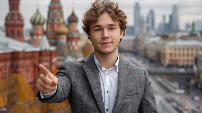 Confident young businessman pointing forward with cityscape background.