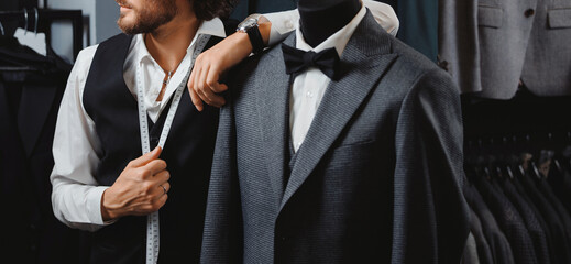 Banner store luxury classic menswear. Tailor man fitting bespoke suit in atelier