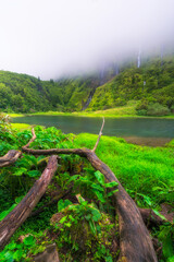 Azores scenic landscape, Flores island. Iconic lagoon with several waterfalls on a single rockface, flowing into lake Alagoinha. Best travel destination in Portugal, amazing vacations place.