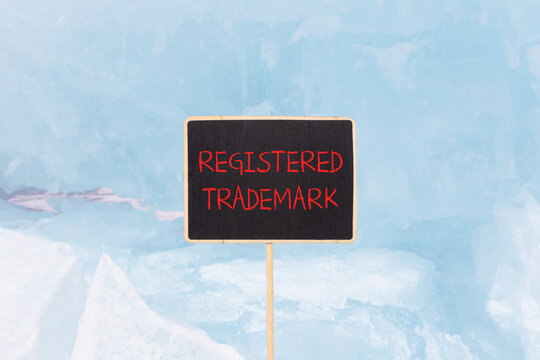 Registered trademark symbol. Concept word Registered trademark on beautiful yellow black blackboard. Beautiful blue ice background. Business and registered trademark concept. Copy space.