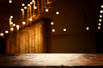 image of wooden table in front of abstract blurred background of restaurant lights