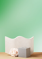 Green gradient background with geometric texture shapes. Cubic gray podium and cream rose