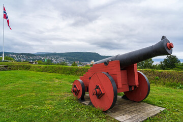 Old Cannon and Norwegian Flag at Kristiansten Festning Fortress in Trondheim - 771691260
