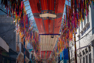Colorful fabrics suspended over the streets around Lake Atitlan. - obrazy, fototapety, plakaty