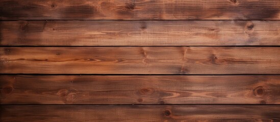 Fototapeta premium A closeup shot of a brown hardwood plank wall with a rich amber wood stain. The intricate pattern of the flooring material adds warmth to the building
