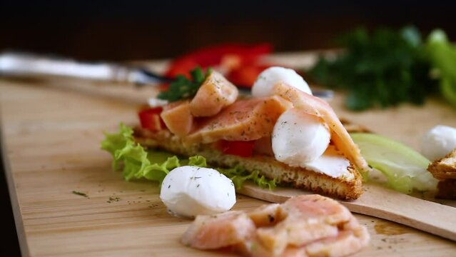 fried toast with salmon, cream cheese, salad, on a wooden table
