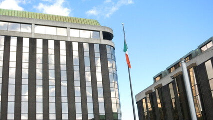 Irish flag on pole, between buildings