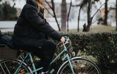 Young woman pausing during a winter bike ride in the park.